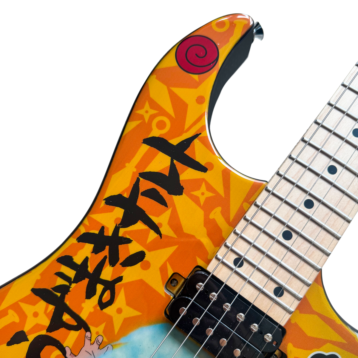 Close-up of the upper horn of the orange Rasengan guitar, with Naruto’s name in kanji and the Uzumaki clan spiral